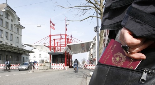 Person mit ausländischem Pass steht vor einem Zollübergang