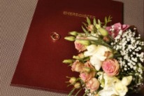 Eheringe und Hochzeitsstrauss liegen auf dem Umschlag Eheregister